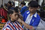 Pemangkas rambut mencukur rambut pelanggan di Kabupaten Ciamis, Jawa Barat, Minggu (7/4/2024). Jelang Lebaran pelaku usaha jasa pangkas rambut bisa melayani sekitar 200 pelanggan yang dikerjakan oleh lima karyawan dengan omzet mencapai Rp3 juta - Rp4 juta per hari. ANTARA FOTO/Adeng Bustomi/agr