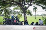 Pemudik bersepeda motor beristirahat di bahu jalan raya pantura, Indramayu, Jawa Barat, Minggu (7/4/2024). Pada H-3 Lebaran, pemudik bersepeda motor dari arah Jakarta menuju Jawa Tengah yang melintas di Jalur Pantura terpantau ramai. ANTARA FOTO/Bayu Pratama S/wsj.