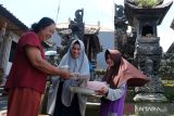 Umat Islam membagikan makanan kepada tetangganya yang beragama Hindu saat tradisi Ngejot di lingkungan Tista, Desa Dapdap Putih, Buleleng, Bali, Selasa (9/4/2024). Tradisi yang digelar sehari sebelum perayaan Idul Fitri 1 Syawal 1445 Hijriah tersebut untuk menjaga silaturahim dan kerukunan antar umat beragama. ANTARA FOTO/Nyoman Hendra Wibowo/wsj.