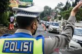 Anggota Kepolisian mengatur lalu lintas kendaraan yang melintas di jalan raya Lembang, Kabupaten Bandung Barat, Jawa Barat, Kamis (11/4/2024). Pada H+1 Idul Fitri 1445 Hijriah, Satlantas Polres Cimahi memberlakukan buka-tutup arus lalu lintas di jalur kawasan wisata Lembang untuk mengurai volume kendaraan yang terpantau padat. ANTARA FOTO/Novrian Arbi/agr