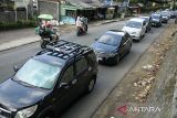 Suasana antrean kendaraan yang melintas di jalan raya Lembang, Kabupaten Bandung Barat, Jawa Barat, Kamis (11/4/2024). Pada H+1 Idul Fitri 1445 Hijriah, Satlantas Polres Cimahi memberlakukan buka-tutup arus lalu lintas di jalur kawasan wisata Lembang untuk mengurai volume kendaraan yang terpantau padat. ANTARA FOTO/Novrian Arbi/agr