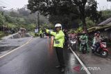 Polisi mengatur arus lalu lintas saat diberlakukan sistem one way atau satu arah di Jalur Selatan, Kadipaten, Kabupaten Tasikmalaya, Jawa Barat, Jumat (12/4/2024). Pada H+2, Dinas Perhubungan (Dishub) Kabupaten Tasikmalaya mencatat volume pemudik pada arus balik Lebaran yang melintas di Jalur Selatan dari arah Tasikmalaya menuju Bandung-Jakarta dan sebaliknya sebanyak 2.435 kendaraan per jam. ANTARA FOTO/Adeng Bustomi/agr
