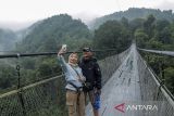 Pengunjung berfoto di jembatan gantung Lembah Purba di kawasan wisata Situgunung, Kadudampit, Kabupaten Sukabumi, Jawa Barat, Jumat (12/4/2024). Menurut pengelola, pada H+1 Idul Fitri sebanyak 5.000 wisatawan mengunjungi obyek wisata di kawasan wisata Situgunung. ANTARA FOTO/Henry Purba/agr
