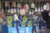 Pemudik melihat makanan dan buah mangga yang dijual di kios-kios di jalan raya Pantura Pilangsari, Jatibarang, Indramayu, Jawa Barat, Sabtu (13/4/2024). Mangga Gedong dan berbagai makanan ringan seperti kerupuk, ikan asin dan lainnya merupakan oleh-oleh khas Indramayu yang diminati para pemudik saat kembali ke Jakarta. ANTARA FOTO/Dedhez Anggara/agr