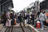 Pemudik berjalan memasuki gerbong kereta api di Stasiun Tasikmalaya, Jawa Barat, Minggu (14/4/2024). PT KAI Daop 2 Bandung mencatat jumlah pemudik pada H+1 hingga H+3 arus balik lebaran tujuan Stasiun Bandung mencapai 55.827 penumpang dengan menyediakan tiket selama masa angkutan lebaran sebanyak 365.692 tiket. ANTARA FOTO/Adeng Bustomi/agr