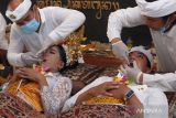 Dua remaja penyandang disabilitas mengikuti ritual Metatah atau potong gigi massal di Taman Prakerti Bhuana, Gianyar, Bali, Senin (15/4/2024). Kegiatan yang digelar Yayasan Peduli Kemanusiaan (YPK) Bali tersebut diikuti 30 penyandang disabilitas fisik dan tunagrahita yang bermakna menghilangkan enam sifat buruk manusia saat mulai beranjak dewasa. ANTARA FOTO/Nyoman Hendra Wibowo/wsj.