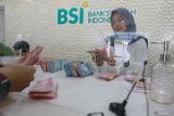 Petugas melayani nasabah yang melakukan penyetoran uang tunai ke rekening di Bank Syariah Indonesia (BSI) Kantor Cabang Banda Aceh, Aceh, Selasa (16/4/2024). Aktivitas layanan perbankan kembali normal sesuai jam operasional seperti biasa usai menerapkan layanan terbatas selama libur dan cuti bersama Hari Raya Idul Fitri 1445 H. ANTARA FOTO/Khalis Surry