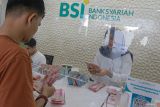 Petugas melayani nasabah yang melakukan penyetoran uang tunai ke rekening di Bank Syariah Indonesia (BSI) Kantor Cabang Banda Aceh, Aceh, Selasa (16/4/2024). Aktivitas layanan perbankan kembali normal sesuai jam operasional seperti biasa usai menerapkan layanan terbatas selama libur dan cuti bersama Hari Raya Idul Fitri 1445 H. ANTARA FOTO/Khalis Surry