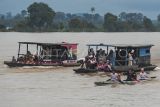 Peserta lomba sisir perahu didampingi pendukungnya yang menggunakan perahu motor menyisiri Sungai Batanghari di Terusan, Batanghari, Jambi, Selasa (16/4/2024). Lomba sisir perahu sepanjang 1.200 meter yang diikuti puluhan perahu di tepi perkampungan tua Terusan itu merupakan tradisi turun temurun masyarakat setempat guna memeriahkan hari Lebaran Idul Fitri. ANTARA FOTO/Wahdi Septiawan/Spt.