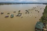 Foto udara peserta lomba sisir perahu didampingi pendukungnya yang menggunakan perahu motor menyisiri Sungai Batanghari di Terusan, Batanghari, Jambi, Selasa (16/4/2024). Lomba sisir perahu sepanjang 1.200 meter yang diikuti puluhan perahu di tepi perkampungan tua Terusan itu merupakan tradisi turun temurun masyarakat setempat guna memeriahkan hari Lebaran Idul Fitri. ANTARA FOTO/Wahdi Septiawan/Spt.