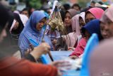Warga antre untuk mendapatkan hidangan saat Lebaran Ketupat di Sukolilo Baru, Surabaya, Jawa Timur, Rabu (17/4/2024). Tradisi Lebaran Ketupat yang dirayakan pada  hari ketujuh setelah Hari Raya Idul Fitri tersebut digelar dengan membagikan berbagai hidangan ketupat secara gratis kepada warga sekitar. Antara Jatim/Didik Suhartono/um