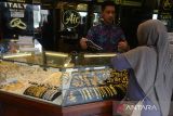 Pedagang emas melayani calon pembeli  di pusat perdagangan  logam mulia  Pasar Aceh, Banda Aceh, Kamis (18/4/2024). Menurut pedagang di daerah itu, meskipun harga emas Antam  sejak  beberapa hari cenderung  menguat dan saat ini berada pada  level Rp1.330.000 per gram atau naik Rp14.000 per gram dari harga sebelumnya dan emas murni Rp3.880.000 per mayam (3,33 gram) atau naik Rp20.000 per gram, namun animo masyarakat membeli  emas lebih besar mencapai 90 persen dibanding penjualan emas hanya 10 persen,  karena mereka memprediksi harga emas  akan terus bergerak naik.  ANTARA FOTO/Ampelsa.
