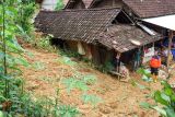 Petugas meninjau rumah terdampak tanah longsor di Desa Sumurup, Trenggalek, Jawa Timur, Sabtu (20/4/2024). BPBD Trenggalek melaporkan sedikitnya 12 rumah warga yang tersebar di lima kecamatan daerah itu dilaporkan rusak berat dan sebagian tidak layak huni akibat terjangan tanah longsor yang mendera wilayah itu sejak Jumat (19/4/2024), sehingga 35 jiwa harus diungsikan sementara ke tempat aman. Antara Jatim/Destyan Sujarwoko/um