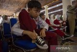 Siswa memakai sepatu baru yang baru diterima di Pendopo Indramayu, Jawa Barat, Senin (22/4/2024). Pemkab Indramayu menyalurkan 1000 pasang sepatu untuk anak-anak tingkat SD dan SMP yang membutuhkan. ANTARA FOTO/Dedhez Anggara/agr
