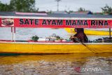 Pasar Terapung Lok Baintan Kalsel. Seorang pedagang menjajakan dagangannya di atas perahu (jukung) di Pasar Terapung Lok Baintan, Kabupaten Banjar, Kalimantan Selatan, Rabu (24/4/2023). Pasar yang berada di aliran Sungai Martapura tersebut merupakan pasar tradisional yang menjual beragam dagangan hasil produksi pertanian dan perkebunan masyarakat setempat dari atas Jukung. ANTARA/Bayu Pratama S.