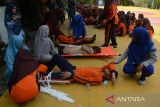 Sejumlah pelajar dalam kondisi terluka dievakuasi  di halaman sekolah saat berlangsung simulasi evakuasi mandiri di SMA 1 Lhoknga, kabupaten Aceh Besar, Aceh, Jumat (26/4/2024). Simulasi gempa dan tsunami yang rutin digelar setiap bulan pada tanggal 26 di sekolah tesebut untuk  meningkatkan kewaspadaan dan pengurangan resiko bencana. ANTARA FOTO/Ampelsa.