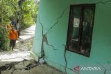 Petugas mengamati tembok rumah yang retak akibat pergerakan tanah di Jatisari, Bojongpicung, Kabupaten Cianjur, Jawa Barat, Sabtu (27/4/2024). Badan Penanggulangan Bencana Daerah (BPBD) Cianjur mencatat sebanyak 34 unit rumah warga rusak, dua fasilitas umum rusak, akses jalan desa retak dan sebanyak 77 Kepala Keluarga (KK) terpaksa mengungsi ke tempat yang aman akibat musibah pergerakan tanah tersebut. ANTARA FOTO/Henry Purba/agr
