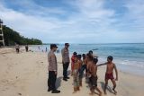 Polisi awasi wisatawan saat bermain di pantai Pesisir Barat