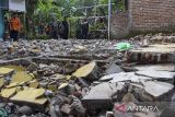 Bupati Tasikmalaya Ade Sugianto (kanan) meninjau rumah warga yang roboh akibat terdampak gempa di Desa Singajaya, Kecamatan Cibalong, Kabupaten Tasikmalaya, Jawa Barat, Minggu (28/4/2024). Berdasarkan data dari BPBD Kabupaten Tasikmalaya sebanyak 19 rumah dan empat fasilitas umum di 12 kecamatan mengalami kerusakan akibat terdampak gempa bumi magnitudo 6.5 di Barat Daya Garut. ANTARA FOTO/Adeng Bustomi/agr