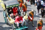 Wakil Wali Kota Madiun Inda Raya Ayu Miko Saputri (kedua kiri) menyapa warga saat kirab budaya di Kota Madiun, Jawa Timur, Minggu (28/4/2024). Kirab budaya tersebut digelar dalam rangka menandai berakhirnya masa jabatan Wali Kota-Wakil Wali Kota Madiun 2019-2024 Maidi-Inda Raya Ayu Miko Saputri. Antara Jatim/Siswowidodo/mas.