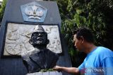 Warga melihat kondisi patung Ki Hajar Dewantara di monumen pendidikan persimpangan Jalan Patimura Kabupaten Jombang, Jawa Timur, Rabu (1/5/2024). Kondisi monumen pendidikan yang didirikan untuk mengenang jasa Ki Hajar Dewantara sebagai bapak pendidikan tersebut dibiarkan tidak terawat dan banyak ditumbuhi rumput liar. Antara Jatim/Syaiful Arif/um