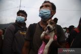 Warga membawa seekor anjing antre saat proses evakuasi menggunakan KRI Kakap-811 di Pelabuhan Tagulandang, Kabupaten Kepulauan Sitaro, Sulawesi Utara, Rabu (1/5/2024).TNI Angkatan Laut (Danlantamal) VIII mengevakuasi sekitar 330 orang yang terdampak erupsi Gunung Ruang dengan menggunakan KRI Kakap-811 menuju Pelabuhan Bitung karena menyusulnya meningkatnya aktivitas gunung yang berada pada status Level IV Awas. ANTARA FOTO/Andri Saputra/wsj.