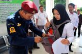 Petugas satuan pengamanan KPU memeriksa tas peserta saat pelaksanaan seleksi tulis calon panitia pemilihan kecamatan (PPK) berbasis Computer Assisted Test (CAT) di gedung SMPN 3 Kota Blitar, Jawa Timur, Senin (6/5/2024). KPU menggelar seleksi tulis calon anggota PPK secara serentak di 508 kabupaten dan kota se-indonesia yang digelar hingga 8 Mei sebagai bagian dari tahapan pelaksanaan Pilkada serentak tahun 2024 yang diatur melalui Peraturan KPU (PKPU) nomor 2 tahun 2024. Antara Jatim/Irfan Anshori/mas.