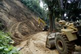 Petugas menggunakan alat berat membersihkan material longsor yang menutup akses Jalan Raya Dampit-Lumajang di Lumajang, Jawa Timur, Rabu (8/5/2024). Berdasarkan laporan Instruktur Tim Reaksi Cepat BPBD Lumajang, longsor yang terjadi pada Selasa (7/5) malam tersebut menyebabkan akses jalan diwilayah tersebut tidak bisa dilewati untuk sementara waktu. Antara Jatim/Irfan Sumanjaya/um 