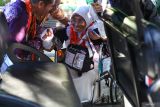 Sejumlah petugas membantu seorang jamaah calon haji lanjut usia duduk di dalam mobil kereta listrik atau buggy car di Asrama Haji Embarkasi Surabaya (AHES), Surabaya, Jawa Timur, Sabtu (11/5/2024). Sebanyak 1.855 jamaah calon haji serta petugas kloter dari kloter 1,2,3,4 dan 5 secara bertahap berdatangan di AHES pada hari ini Sabtu (11/5). Antara Jatim/Didik Suhartono/um 