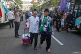 Sejumlah calon haji berjalan menuju bus saat pemberangkatan di Pendopo Malowopati, Bojonegoro, Jawa Timur, Sabtu (11/5/2024). Sebanyak 1.543 jamaah calon haji asal Kabupaten Bojonegoro yang terbagi dalam lima kloter diberangkatkan ke Embarkasi Surabaya sebelum menuju Tanah Suci Mekah. Antara Jatim/Muhammad Mada/um