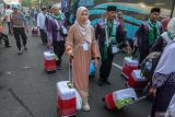 Sejumlah calon haji berjalan menuju bus saat pemberangkatan di Pendopo Malowopati, Bojonegoro, Jawa Timur, Sabtu (11/5/2024). Sebanyak 1.543 jamaah calon haji asal Kabupaten Bojonegoro yang terbagi dalam lima kloter diberangkatkan ke Embarkasi Surabaya sebelum menuju Tanah Suci Mekah. Antara Jatim/Muhammad Mada/um