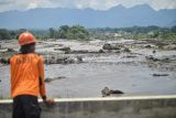 Petugas melihat mobil yang terdampak banjir bandang di Nagari Bukik Batabuah, Agam, Sumatera Barat, Minggu (12/5/2024). Banjir bandang akibat meluapnya aliran air lahar dingin Gunung Marapi serta hujan deras di daerah itu mengakibatkan 18 tewas, sejumlah rumah rusak dan ratusan warga diungsikan. ANTARA FOTO/Iggo El Fitra/Lmo/Spt. 