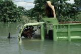 Sopir truk bertahan di atas kendaraanya saat terjebak banjir bandang luapan Sungai Lalindu di Desa Sambandete, Kecamatan Oheo, Konawe Utara, Sulawesi Tenggara, Sabtu (11/5/2024). Banjir bandang tersebut menyebabkan akses jalan trans Sulawesi terputus dan sejumlah kendaraan terjebak banjir. ANTARA FOTO/Jojon/aww.

