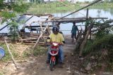 Warga memanfaatkan perahu penyeberangan di kawasan proyek pembangunan jembatan Mrican, Desa Jongbiru, Kediri, Jawa Timur, Senin (13/5/2024). Warga memanfaatkan layanan perahu penyeberangan sungai Brantas dengan tarif Rp2.000 per orang yang menghubungkan Kabupaten Kediri dengan Kota Kediri seiring belum selesainya pembangunan jembatan Mrican. Antara Jatim/Prasetia Fauzani/mas.