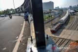 Warga melihat kereta api yang melintas di bawah Jembatan Layang Ciroyom, Bandung, Jawa Barat, Senin (13/5/2024). Proyek Jembatan Layang Ciroyom yang ditujukan untuk mengurai kemacetan tersebut sudah rampung dikerjakan dan telah dioperasikan meskipun belum diresmikan oleh pemerintah. ANTARA FOTO/Raisan Al Farisi/agr
