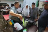 Petugas Kantor Kementerian Agama Aceh Besar memperlihatkan isi koper kepada jamaah calon haji Aceh Besar saat pembagian koper kepada jamaah di Banda Aceh, Aceh, Selasa (14/5/2024). Kantor Wilayah Kementerian Agama Provinsi Aceh mendistribusikan koper dan logistik lainnya bagi 4.709 jamaah calon haji tahun 2024 untuk persiapan keberangkatan haji 1445 H mulai 29 Mei 2024 untuk kelompok terbang pertama dari total 12 kloter Embarkasi Aceh. ANTARA FOTO/Khalis Surry