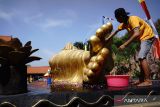 Warga membersihkan patung Buddha tidur di area Maha Vihara Mojopahit Bejijong, Kecamatan Trowulan, Kabupaten Mojokerto, Jawa Timur, Rabu (15/5/2024). Tradisi membersihkan patung Buddha tidur berukuran panjang 22 meter, lebar enam meter dan tinggi 4,5 meter tersebut merupakan rangkaian peringatan menjelang perayaan Hari Raya Waisak 2568 BE. Antara Jatim/Syaiful Arif/um