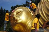 Warga membersihkan patung Buddha tidur di area Maha Vihara Mojopahit Bejijong, Kecamatan Trowulan, Kabupaten Mojokerto, Jawa Timur, Rabu (15/5/2024). Tradisi membersihkan patung Buddha tidur berukuran panjang 22 meter, lebar enam meter dan tinggi 4,5 meter tersebut merupakan rangkaian peringatan menjelang perayaan Hari Raya Waisak 2568 BE. Antara Jatim/Syaiful Arif/um