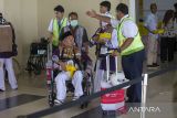 Petugas bandara membantu jamaah calon haji untuk diberangkatkan ke bandara di Asrama haji Embarkasi Kertajati, Indramayu, Jawa Barat, Rabu (15/5/2024). Panitia Penyelenggara Ibadah Haji (PPIH) Embarkasi Kertajati menerapkan layanan terpadu satu atap untuk jamaah calon haji dengan langsung dilakukan pengecekan kesehatan, pemberian gelang, uang saku, dokumen visa dan paspor hingga pemeriksaan X-ray di Asrama haji sehingga lebih ringkas dan jamaah calon haji dapat langsung masuk pesawat setibanya di bandara. ANTARA FOTO/Dedhez Anggara/agr
