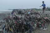 Seorang anak bermain di antara tumpukan sampah di Pantai Cibutun Loji, Desa Sangrawayang, Simpenan, Kabupaten Sukabumi, Jawa Barat, Sabtu (11/5/2024). Menurut warga setempat, sudah sepekan terakhir sampah rumah tangga yang terbawa arus laut tersebut menumpuk di pesisir pantai yang selain mencemari lingkungan juga menghambat aktivitas perahu nelayan yang akan melaut. ANTARA FOTO/Henry Purba/agr/aww.