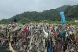 Warga melintas di sekitar tumpukan sampah di Pantai Cibutun Loji, Desa Sangrawayang, Simpenan, Kabupaten Sukabumi, Jawa Barat, Sabtu (11/5/2024). Menurut warga setempat, sudah sepekan terakhir sampah rumah tangga yang terbawa arus laut tersebut menumpuk di pesisir pantai yang selain mencemari lingkungan juga menghambat aktivitas perahu nelayan yang akan melaut. ANTARA FOTO/Henry Purba/agr/aww.