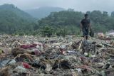 Warga melintas di sekitar tumpukan sampah di Pantai Cibutun Loji, Desa Sangrawayang, Simpenan, Kabupaten Sukabumi, Jawa Barat, Sabtu (11/5/2024). Menurut warga setempat, sudah sepekan terakhir sampah rumah tangga yang terbawa arus laut tersebut menumpuk di pesisir pantai yang selain mencemari lingkungan juga menghambat aktivitas perahu nelayan yang akan melaut. ANTARA FOTO/Henry Purba/agr/aww.