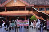 Pembimbing muatan lokal menggelar aksi damai di halaman sekolah dasar (SD) Plus Darul Ulum Kabupaten Jombang, Jawa Timur, Sabtu (18/5/2024). Mereka mendesak pihak kepolisian untuk membebaskan guru diniyah yang ditetapkan sebagai tersangka dugaan kelalaian yang mengakibatkan mata salah seorang siswa cedera akibat terkena lemparan kayu gagang sapu temannya saat menunggu jam pelajaran diniyah. Antara Jatim/Syaiful Arif/um