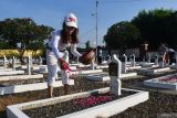 Sejumlah umat Buddha menabur bunga saat berziarah di Taman Makam Pahlawan (TMP) Madiun, Jawa Timur, Sabtu (18/5/2024). Kegiatan ziarah dan tabur bunga tersebut dilakukan dalam rangkaian kegiatan menyambut Hari Raya Waisak 2568 BE/2024. Antara Jatim/Siswowidodo/um 