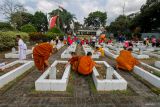 Sejumlah Bhikkhu menabur bunga saat berziarah di Taman Makam Pahlawan (TMP) Batu, Jawa Timur, Minggu (19/5/2024). Kegiatan ziarah dan tabur bunga tersebut dilakukan dalam rangkaian menyambut Hari Raya Waisak 2568 BE/2024. Antara Jatim/Muhammad Mada/um 