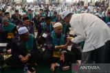 Ketua Majellis Permusyawaratan Ulama (MPU) kabupaten Aceh Besar, Tengku Nasruddin (kanan) melakukan tradisi peusijuk (tepung tawar) kepada jamaah calon haji (JCH) kloter pertama  saat pelepasan menuju asrama haji embarkasi Aceh di Masjid Baitul Makmur, kabupaten Aceh Besar, Aceh, Selasa (28/5/2024).  Pemerintah Aceh akan memberangkatkan sebanyak  393 jamaah calon haji (JCH) yang tergabung dalam kloter pertama asal kabupaten Aceh Besar dan Sabang  ke Arab Saudi  melalui embarkasi  Aceh.  ANTARA FOTO/Ampelsa.