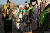 Petugas membantu jamaah haji yang tergabung dalam kloter pertama Embarkasi Aceh untuk menaiki pesawat Garuda Indonesia di Bandara Sultan Iskanda Muda (SIM) Aceh Besar, Aceh, Rabu (29/5/2024). Panitia Penyelenggara Ibadah Haji (PPIH) Embarkasi Aceh resmi memberangkatkan ke Tanah Suci sebanyak 393 jamaah calon haji kelompok terbang pertama yang berasal dari Kabupaten Aceh Besar dan Kota Sabang, dari total 4.710 kuota haji Aceh untuk beribadah haji tahun 1445 H/2024 M. ANTARA FOTO/Khalis Surry