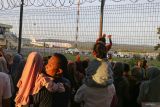 Keluarga jamaah haji melihat pesawat Garuda Indonesia yang mengangkut jamaah haji kloter pertama Embarkasi Aceh saat hendak lepas landas di Bandara Sultan Iskanda Muda (SIM) Aceh Besar, Aceh, Rabu (29/5/2024). Panitia Penyelenggara Ibadah Haji (PPIH) Embarkasi Aceh resmi memberangkatkan ke Tanah Suci sebanyak 393 jamaah calon haji kelompok terbang pertama yang berasal dari Kabupaten Aceh Besar dan Kota Sabang, dari total 4.710 kuota haji Aceh untuk beribadah haji tahun 1445 H/2024 M. ANTARA FOTO/Khalis Surry