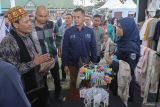 Asisten Perekonomian dan Pembangunan Sekda Aceh Zulkifli (kiri) didampingi CEO Rumah BUMN Aceh Helmi Fadli (kedua kanan) saat melihat produk ecoprint produksi dari UMKM Rumah BUMN Sabang pada acara Karya Nyata Festival Vol.7 di Lapangan Blang Padang, Banda Aceh, Aceh, Sabtu (1/6/2024). Karya Nyata Festival Vol.7 yang digagas oleh Kementerian BUMN melibatkan 86 pelaku UMKM dari seluruh Aceh sebagai wujud keseriusan pemerintah melalui Rumah BUMN dalam mendukung sektor UMKM di Indonesia untuk naik kelas sehingga bisa tumbuh lebih maju. ANTARA FOTO/Khalis Surry