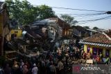 Warga dibantu petugas kepolisian mengevakuasi barang di rumah yang rusak terdampak pipa milik PDAM Tirtawening yang pecah di Cibangkong, Bandung, Jawa Barat, Kamis (6/6/2024). Sedikitnya dua rumah yang dihuni 10 jiwa mengalami rusak berat serta tebing pembatas anak sungai Cikapundung sepanjang 50 meter roboh tedampak luapan air dari rusaknya pipa saluran air yang terjadi pada rabu (5/6). ANTARA FOTO/Novrian Arbi/agr